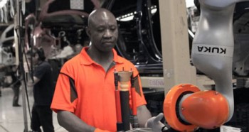 A worker at Ford’s factory in Cologne, Germany, gives the heavy suspension parts for the Ford Fiesta to LBR iiwa for insertion into the vehicle. Photo by KUKA Roboter GmbH 